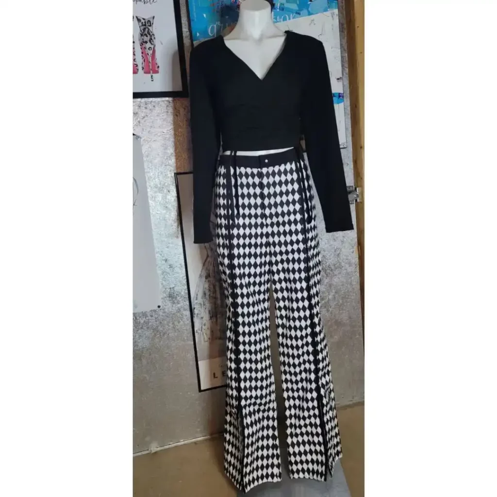cropped black shirt with long sleeves paired with checkered pants on a mannequin