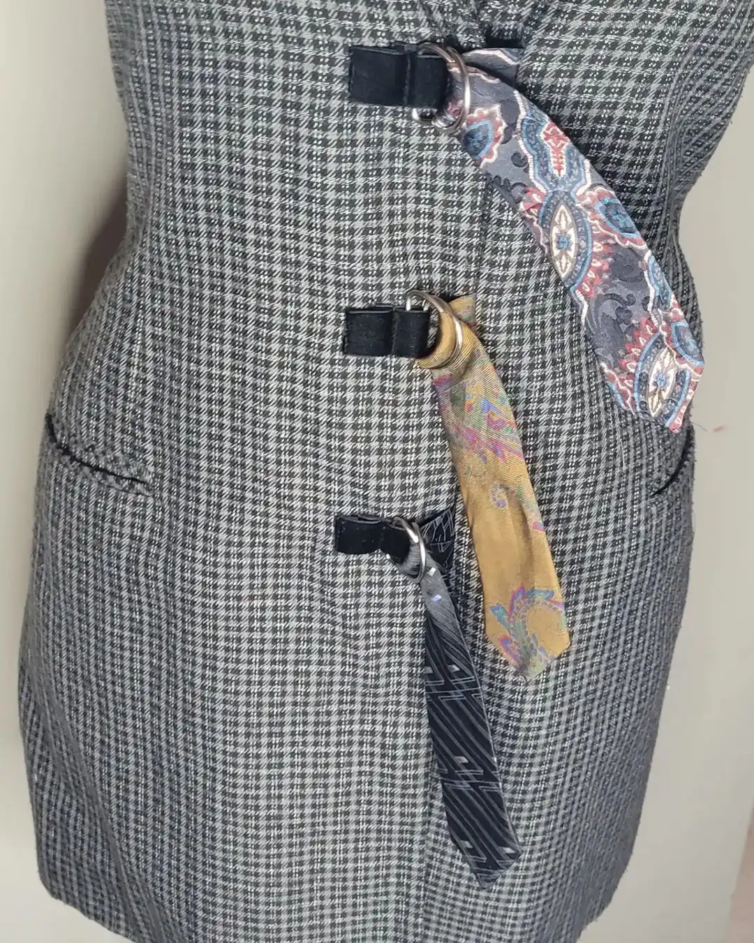 side of plaid dress that is cinched with 3 different ties through metal loops